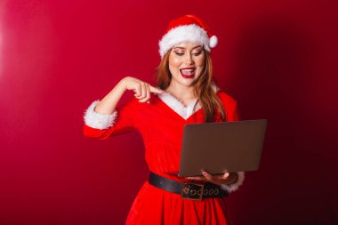 Güzel Brezilyalı kızıl saçlı kadın, Noel kıyafetleri giymiş, Noel Baba. Not defterini tutuyorum. İnanılmaz, inanılmaz..