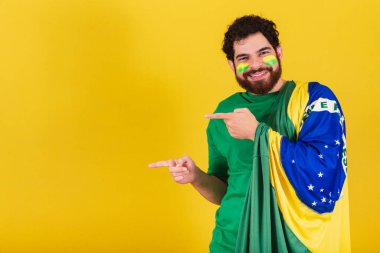 Sakallı, Brezilyalı, Brezilyalı, futbol taraftarı, sol eli işaret eden, reklam için fotoğraf çeken,.
