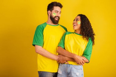 İki Brezilyalı futbol taraftarı, ulusun renginde giyinmiş, siyah kadın, beyaz erkek. benimsenmiş.