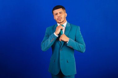 Brezilyalı siyah bir adam, takım elbise ve mavi kravat takmış. İş adamı. kravat düzelt