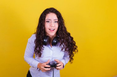 Kulaklıklı bir kadın joystick ile video oyunu oynuyor. Oyuncu kadın..