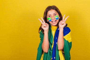 Brezilyalı, beyaz çocuk, barış ve sevginin ifadesi, parmaklar havada, fotoğraf için mutlu poz. Dünya Kupası. Olimpiyatlar. futbol taraftarı