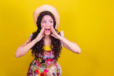 Festa Junina için tipik kıyafetler giymiş güzel bir kadın. Bağırmak, çağırmak, yüksek sesle promosyon demek, indirim..