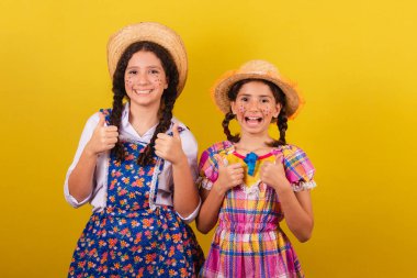 Festa Junina 'nın tipik kıyafetlerini giyiyorlar. Başparmak yukarı. Olumlu. Olumlu. Onaylama.