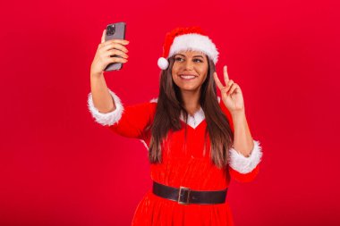 Noel kıyafetleri giymiş güzel Brezilyalı kadın, Noel Baba. Akıllı telefon tutup kendi portremi çekiyordum..