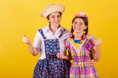 Büyükanne ve torun tipik Festa Junina kıyafetleri giymişler. Kutlama, zafer, parti.