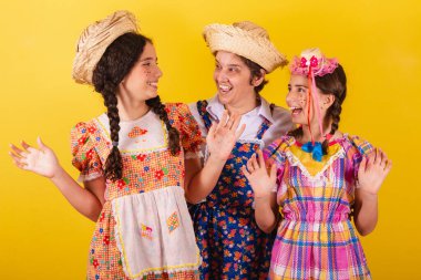 Büyükannesi ve iki torunu tipik Festa Junina kıyafetleri giymişler. Şaşırmış, şaşırmış, vay canına, inanılmaz.