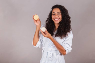 Bornoz ve havlu giymiş Brezilyalı siyahi kadın. Güzellik, cilt ve saç bakımı için vejetaryen ürünleri. sabun, spa, kişisel bakım. Refah.