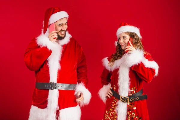 Brezilyalı Çift Noel Kıyafetleri Içinde Noel Baba Akıllı Telefon Kullanıyorlar — Stok fotoğraf