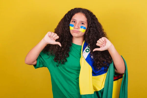 Brazilian, Caucasian girl, football fan, disapproval, thumbs down, negative, sad, unhappy.