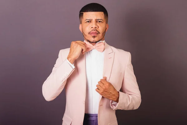 ブラジルの黒人男性ピンクのスーツと蝶ネクタイグレーの背景固定ネクタイ — ストック写真