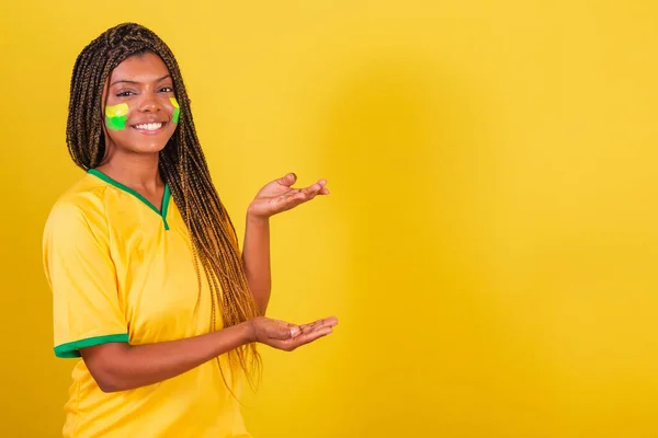 年轻的巴西黑人女子足球迷 向右展示某事 宣传照片 — 图库照片