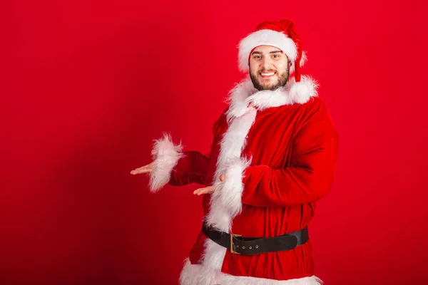 Кавказький Бразильський Чоловік Одягнений Різдвяний Одяг Санта Клаус Показуючи Продукт — стокове фото