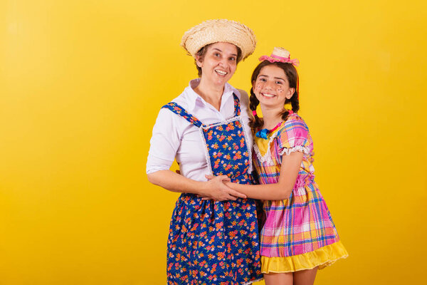 бабушка и внучка одеты в типичную одежду Фесты Джунины. обниматься и улыбаться.