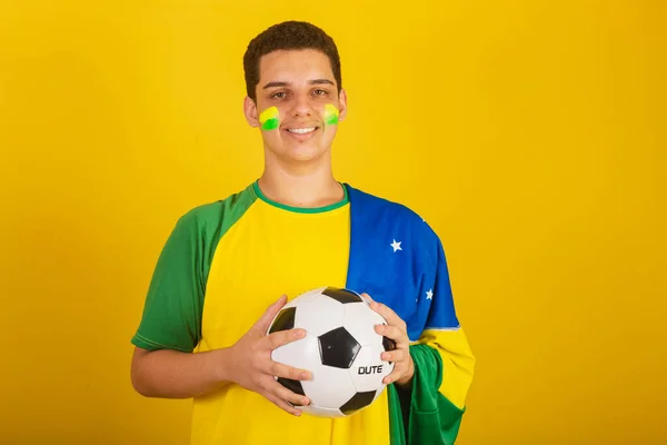 Młody Brazylijski Fan Piłki Nożnej Ubrany Zielono Trzymając Piłkę Brazylijską — Zdjęcie stockowe
