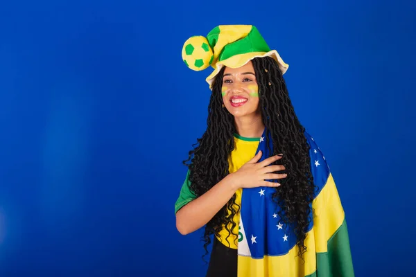 若い黒人のブラジル人女性サッカーファン ブラジルの国旗です 胸を手に感謝します — ストック写真