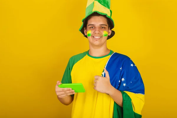 Młody Brazylijski Fan Piłki Nożnej Ubrany Zielono Pomocą Smartfona Telefonu — Zdjęcie stockowe