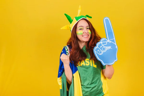 caucasian redhead woman brazil soccer fan wearing foam finger cheering, partying and celebrating championship.