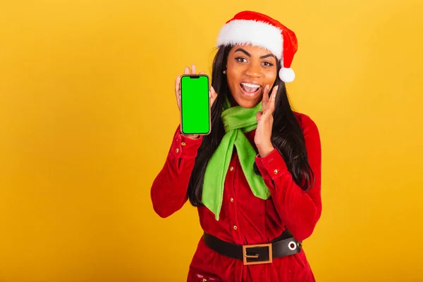 美丽的巴西黑人女人 身穿圣诞服装 圣诞灯笼 智能手机 还有绿色的彩色屏风 — 图库照片