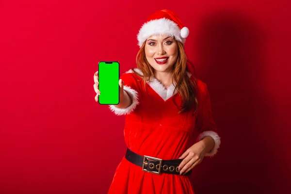 美丽的巴西红头发女人 穿着圣诞服装 圣诞老人 显示带有绿色彩色屏幕的智能手机 — 图库照片