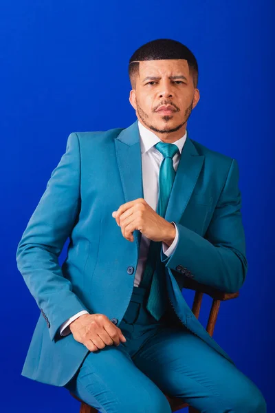 スーツと青いネクタイを着たブラジルの黒人男性 ビジネスマン 木製の椅子のポーズ — ストック写真