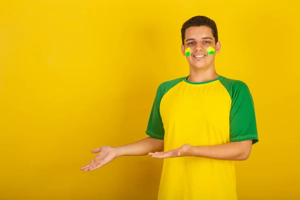 Fiatal Brazil Férfi Focirajongó Zöld Ruhába Öltözve Bemutatva Valamit — Stock Fotó