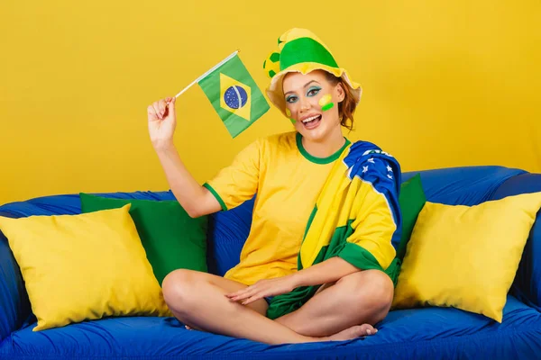 Καυκάσια Γυναίκα Κοκκινομάλλα Οπαδός Ποδοσφαίρου Βραζιλίας Βραζιλιάνα Στον Καναπέ Κρατώντας — Φωτογραφία Αρχείου
