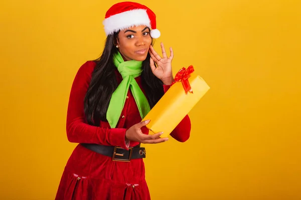 Schöne Schwarze Brasilianerin Weihnachtskleidung Weihnachtsmann Deutet Auf Gelbes Geschenk Zweifel — Stockfoto