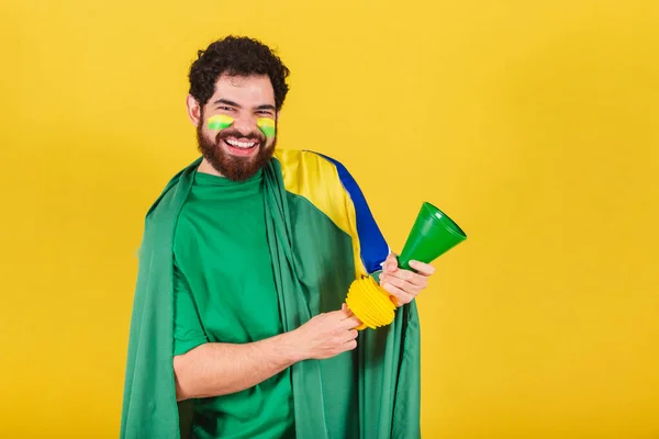 ブラジル出身の男 ブラジル人 ひげを生やしたサッカーファン ワールドカップの試合でホーンを使い パーティーをし 騒音を出す — ストック写真