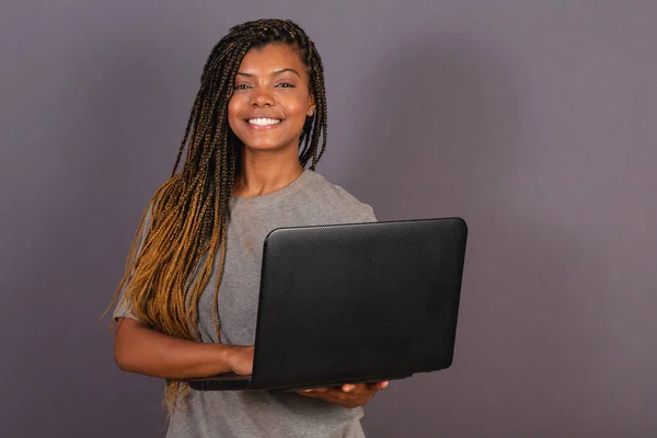 年轻的非洲裔巴西妇女 手持笔记本电脑 用笔记本电脑工作 — 图库照片