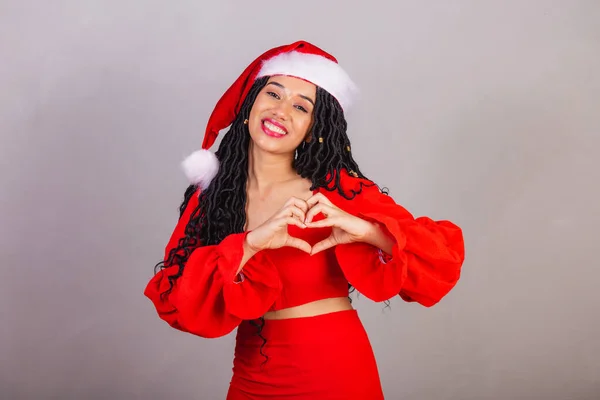ブラジルの黒人女性クリスマス服を着て陽気なクリスマス笑顔ハートサイン — ストック写真