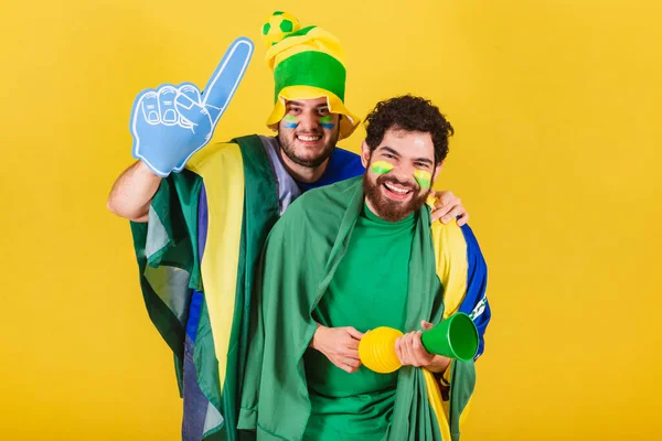 ブラジル人 ブラジル人 サッカーファンの2人の友人がブラジルの旗 ホーン エスクパの指を使って勝利を祝いゴールを叫ぶ — ストック写真