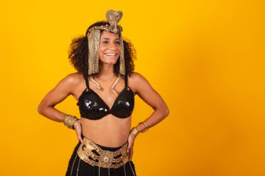 Kleopatra karnaval kıyafetleri içinde güzel siyah Brezilyalı kadın, elleri kalçasında.