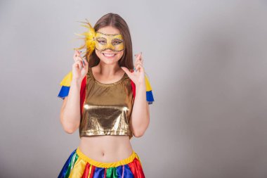 Brezilyalı sarışın kadın, açık renk kıyafetler, karnaval maskesi, parmakları olan şanslı tabela,.