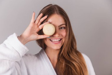 Bornoz giymiş güzel Brezilyalı kadın cilt bakımı için sabun tutuyor. yakın plan fotoğraf.