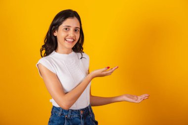 Güzel Brezilyalı kadın sağ tarafa bir şey sunuyor..