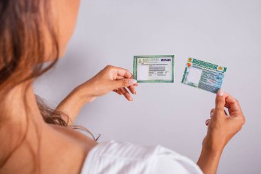 Sürücü ehliyeti ve kimlik kartı tutan eller. Brezilya belgeleri.