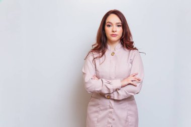 Brezilyalı kadın, kızıl saçlı, güzellik uzmanı, güzellik uzmanı, kollarını kavuşturmuş. İyimser ve kendinden emin..