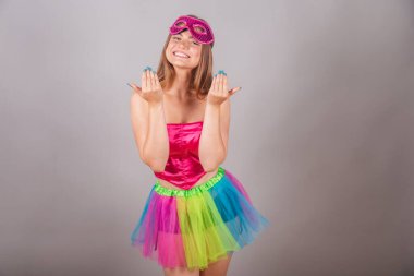 Pembe karnaval kıyafetleri giymiş Brezilyalı sarışın kadın. Maskeli, gel, ellerinle davet et..