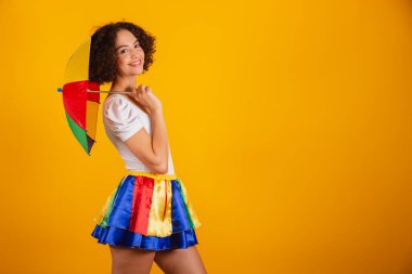 Güzel Brezilyalı kadın, karnaval kıyafetleri, renkli etek ve beyaz gömlek giymiş. Elin kalçanda gülümsüyorsun..