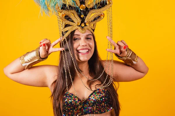 身穿金色狂欢节服装 头戴狂欢节舞蹈羽冠的美丽的巴西女人 和平与爱情 自作主张 — 图库照片