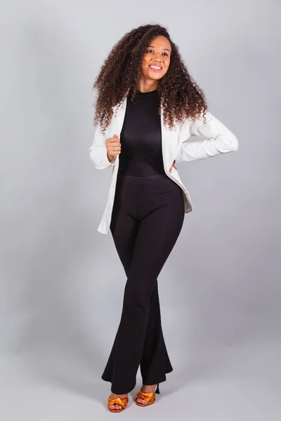 stock image vertical photo, beautiful black Brazilian woman, businesswoman, wearing white suit, smiling, optimistic.