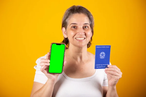 巴西成年妇女 持有工作和社会保障卡 绿屏智能手机 — 图库照片