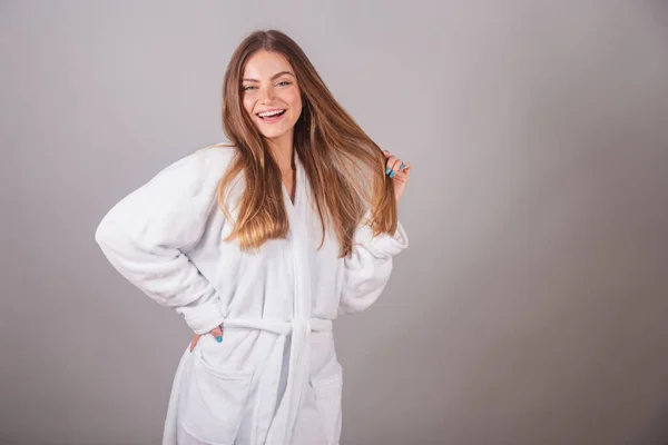 stock image Brazilian blonde woman showing wonderful hair. Wearing a bathrobe. Messing with hair, hair with movement.