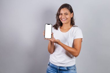 Brezilyalı kadın, akıllı telefonlu, reklamlar ve reklamlar için beyaz ekran gösteriyor..