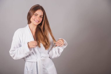 Harika saçları olan Brezilyalı sarışın kadın. Bornoz giyiyordu. Saçla uğraşırken, saçla dolaşırken.