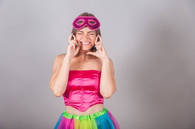 Pembe karnaval kıyafetleri giymiş Brezilyalı sarışın kadın. Rimel, şans işareti, tezahürat. Dilek.