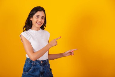 Güzel Brezilyalı kadın sağ tarafa bir şey sunuyor..