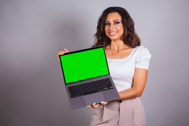 Elinde defter tutan Brezilyalı kadın. İnternet 'e, web sitelerine, bilgisayarlara bakıyorum. İnternet.