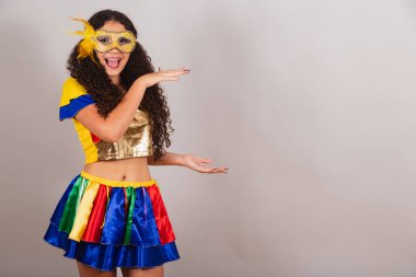 Genç bir kız, Brezilyalı, Frevo elbiseli, karnaval. Rimel, yan taraftaki ürünü gösteriyor..